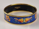 blue and gold bangle with flowers and leaves on a white surface