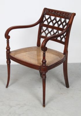 an image of a wooden chair with a woven seat and arms