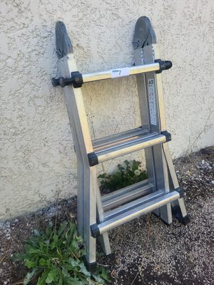 une échelle appuyée contre un mur à côté d'un immeuble