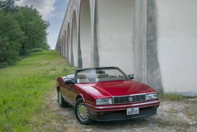 a red car that is parked in front of a wall