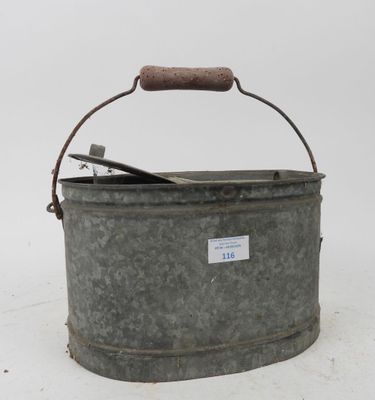 a metal bucket with a wooden handle on a white surface