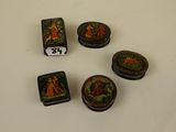 four small decorative boxes are sitting on a white surface