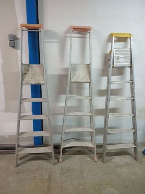 plusieurs échelles sont alignées contre un mur dans une pièce