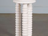 une image représentant une table en marbre blanc avec un piètement rond