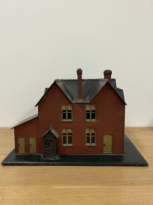 a small model of a red house on a table