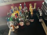 Des bouteilles d'alcool sont alignées sur une table à côté d'une valise