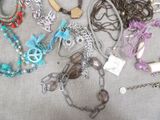 many different necklaces and bracelets laid out on a table