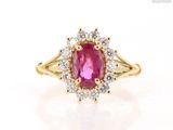 a close up of a pink sapphire and diamond ring on a white surface