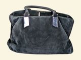 grey sued handbag with leather handles on a white background