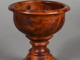 an image of a wooden bowl on a pedestal on a gray background