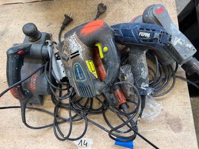 un tas d'outils électriques par terre, à côté d'un tas de câbles