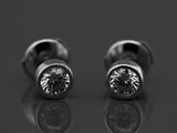 une paire de boucles d'oreilles en diamant posée sur une surface réfléchissante