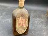 a bottle of galaa on a table next to a bell