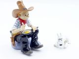 a figurine of a cowboy sitting on a chair next to a dog