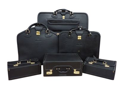 six pieces of black luggage sitting next to each other on a white surface