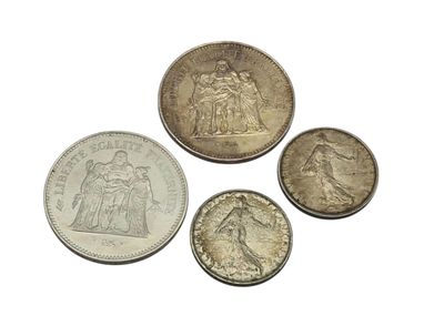 four different types of silver coins on a white surface