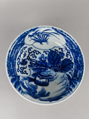 a blue and white plate with a bird and flowers on it