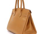 a tan leather handbag on a white background