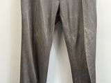 un pantalon gris suspendu à un cintre devant un mur blanc