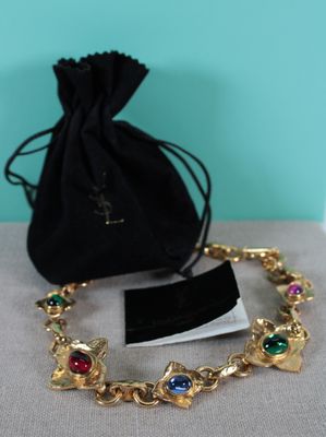a close up of a bracelet with a bag on a table