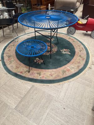 a blue table and two blue chairs in the middle of a living room