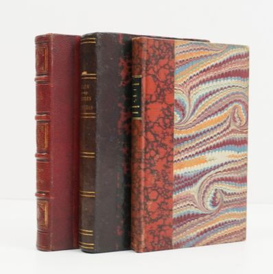 trois livres sont empilés sur une surface blanche