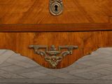 a small wooden chest of drawers with a key on it