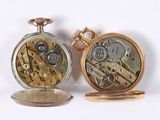 two different types of pocket watches sitting next to each other