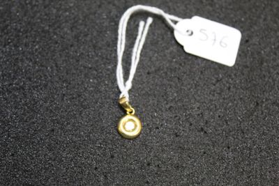 a necklace with a small gold disc on it