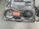 une personne se tient à côté d'un outil rangé dans une mallette posée par terre
