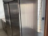 a stainless steel refrigerator in a kitchen with tile flooring