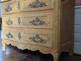 a dresser in the middle of a room with a vase on top of it