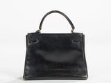 a black handbag sitting on top of a white surface