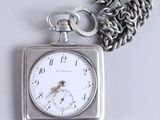 a silver pocket watch with a chain attached to it