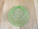 a green glass plate sitting on a wooden table