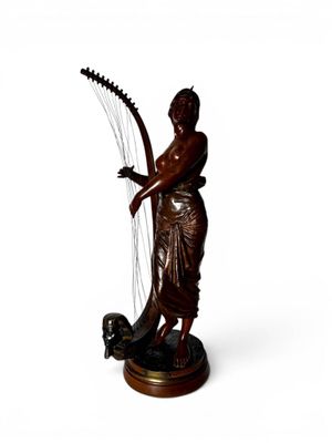 statue d'une femme avec une harpe et un chien