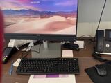 a desk with a computer, keyboard, mouse and other items on it