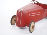 a red toy car that is sitting on a white surface