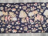 un gros plan d'un tapis posé sur un parquet, orné de fleurs et d'animaux