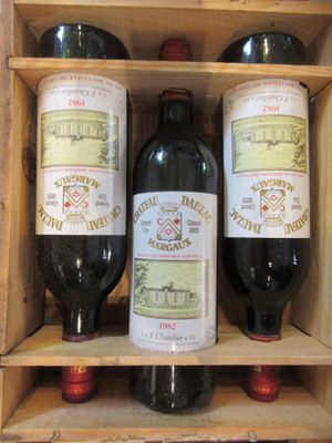 trois bouteilles de vin posées sur une étagère en bois