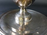 a silver plate with a flower on it on a table