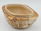 a white bowl with a gold decoration on it
