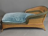 pair of wicker lounge chairs with blue velvet cushions and matching foot stools