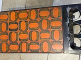 an orange and black pattern on the floor of a public restroom