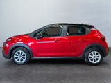 a red car is parked in a room with a white wall