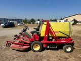 a red lawn mower sitting on top of a dirt field