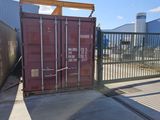 a red shipping container sitting in the middle of a parking lot