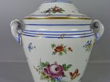 un vase blanc et bleu orné de fleurs et de papillons