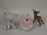 three figurines of animals and a bird on a white surface