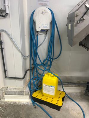 un objet jaune et bleu posé par terre à côté d'un tuyau bleu